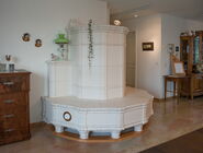 Runder, weisser Kachelofen mit Sitzbank